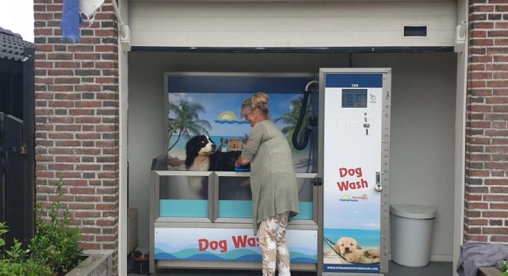 Dog Wash met een hond erin en een persoon ernaast die de hond wast